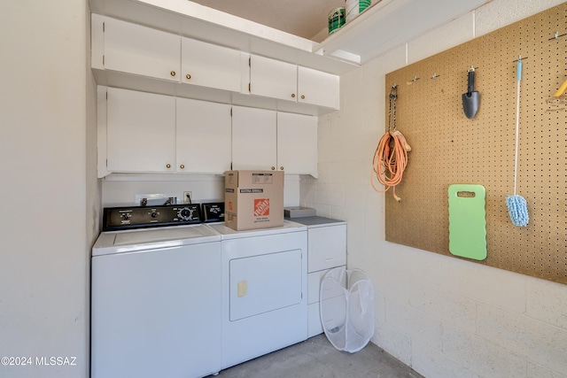 clothes washing area featuring cabinets and washer and dryer