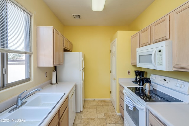 kitchen featuring light brown cabinetry, white appliances, and sink