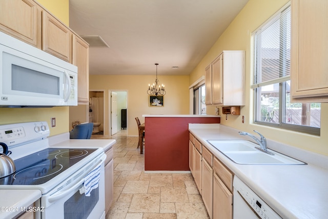 kitchen featuring white appliances, sink, light brown cabinets, decorative light fixtures, and a notable chandelier