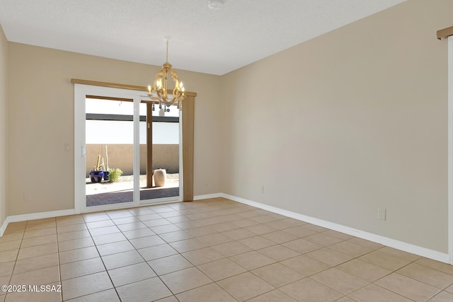 empty room with a chandelier, a textured ceiling, baseboards, and light tile patterned floors