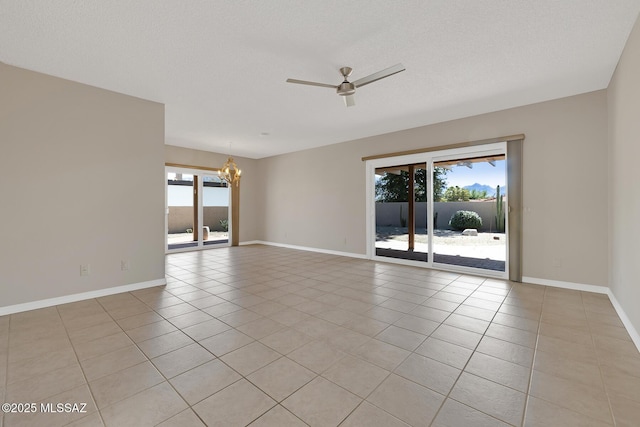 spare room featuring light tile patterned floors, a textured ceiling, a wealth of natural light, and ceiling fan with notable chandelier