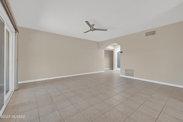 empty room with ceiling fan, visible vents, and baseboards