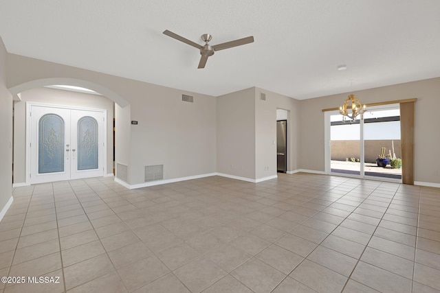 unfurnished living room with ceiling fan with notable chandelier, visible vents, and light tile patterned floors