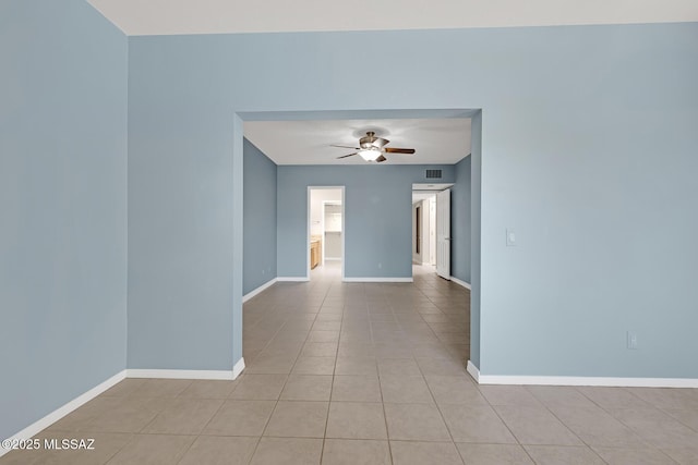 unfurnished room with a ceiling fan, visible vents, baseboards, and light tile patterned floors