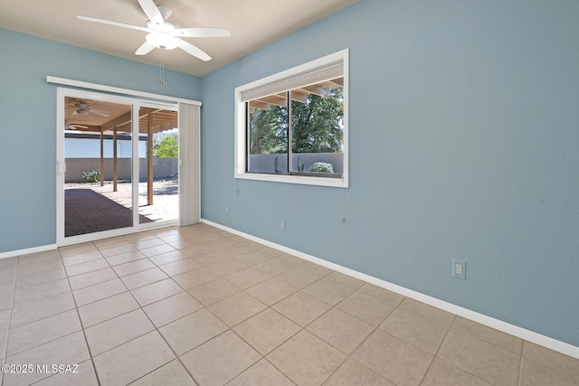 spare room featuring a ceiling fan, baseboards, and light tile patterned floors