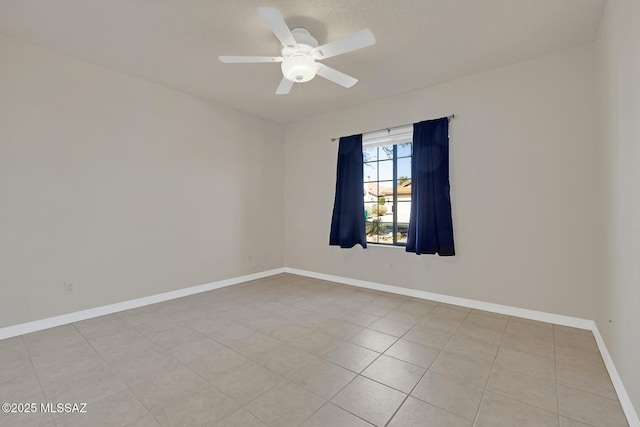 spare room featuring baseboards and a ceiling fan