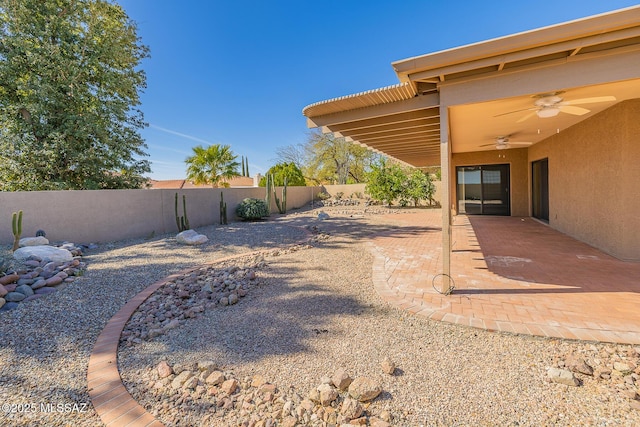 view of yard with a ceiling fan, a patio area, and a fenced backyard