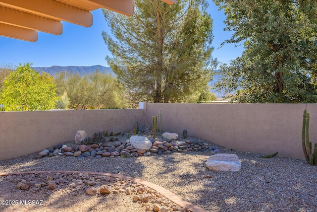 view of yard featuring a fenced backyard and a mountain view