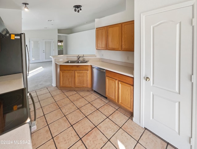 kitchen with light tile patterned flooring, stainless steel appliances, sink, vaulted ceiling, and kitchen peninsula