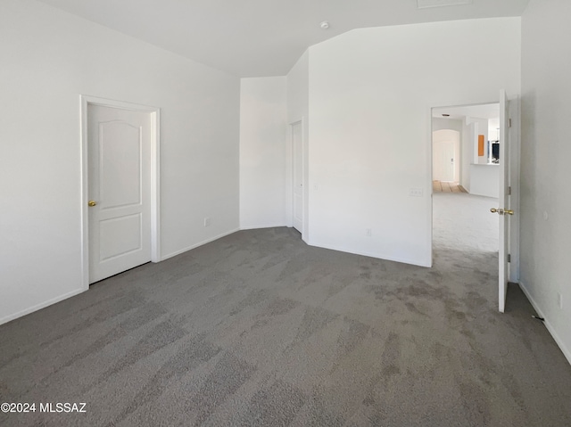 empty room with lofted ceiling and carpet