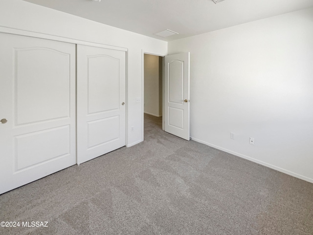 unfurnished bedroom featuring a closet and light carpet