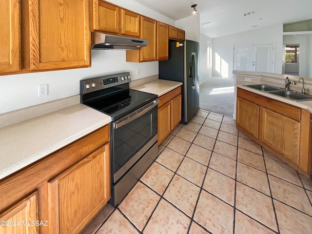 kitchen with appliances with stainless steel finishes, sink, lofted ceiling, and light tile patterned floors