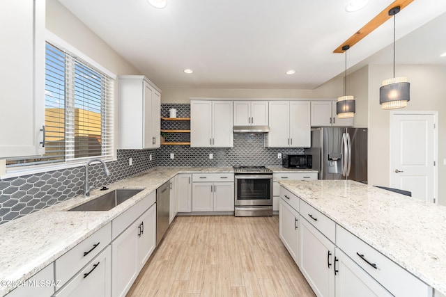 kitchen featuring white cabinetry, sink, stainless steel appliances, backsplash, and pendant lighting