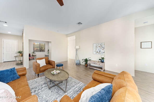 living room featuring light hardwood / wood-style flooring and ceiling fan