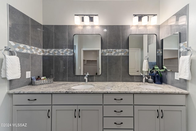 bathroom with tasteful backsplash, vanity, and tile walls