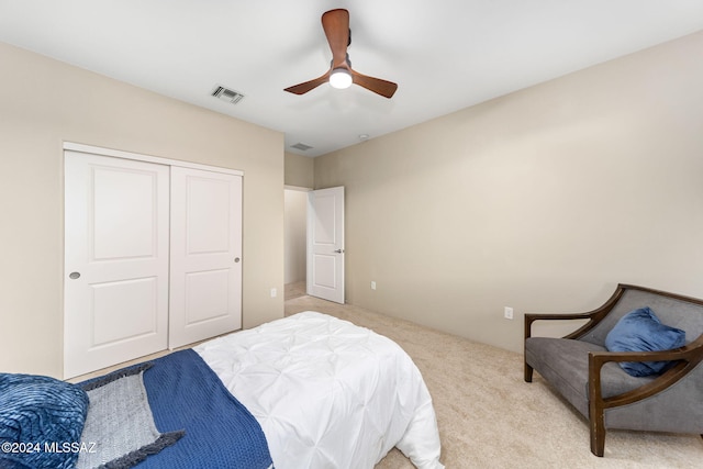 bedroom featuring light carpet, a closet, and ceiling fan