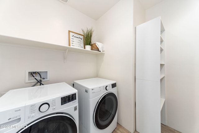 laundry area featuring light hardwood / wood-style floors and washing machine and clothes dryer