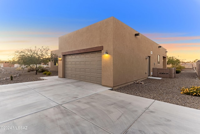 property exterior at dusk featuring a garage