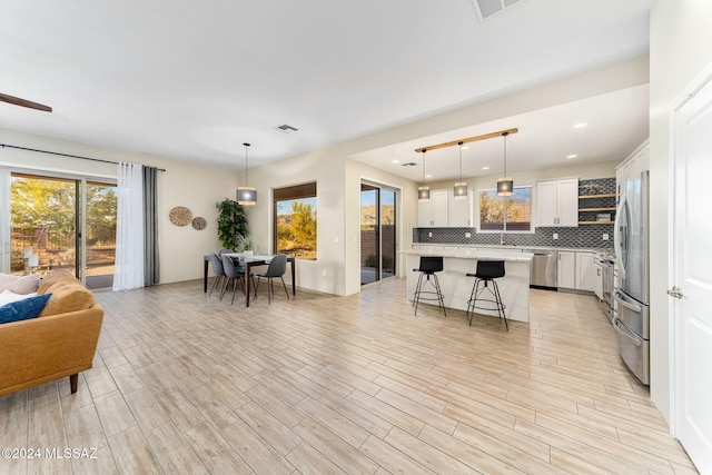 kitchen with pendant lighting, a center island, tasteful backsplash, and white cabinetry