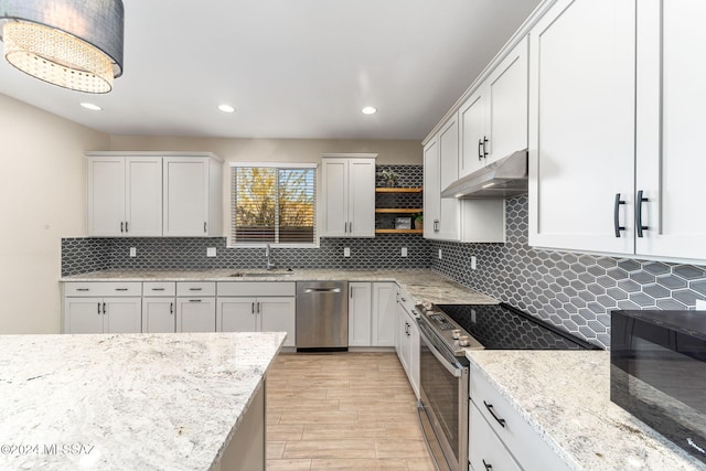 kitchen featuring decorative backsplash, appliances with stainless steel finishes, light stone counters, sink, and white cabinets