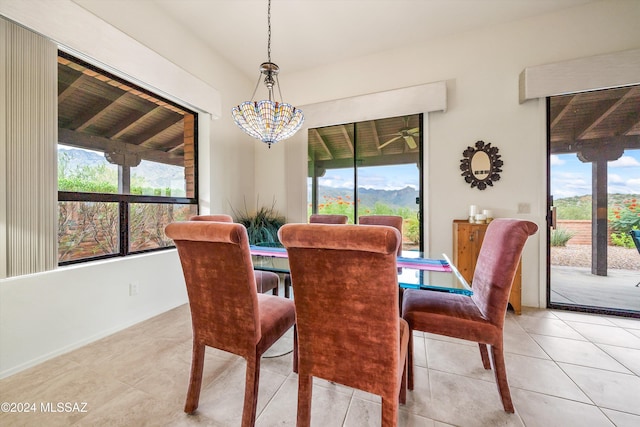 tiled dining space featuring a healthy amount of sunlight and a notable chandelier