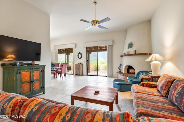 living room featuring ceiling fan, light tile patterned floors, a fireplace, and high vaulted ceiling