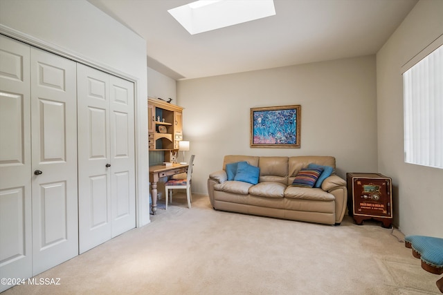 living area with a skylight and light colored carpet