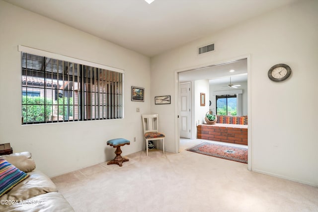 sitting room featuring ceiling fan and carpet floors