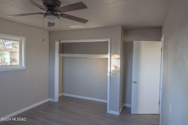 unfurnished bedroom with hardwood / wood-style floors, a closet, and ceiling fan