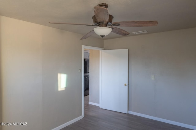 spare room with ceiling fan and dark hardwood / wood-style flooring