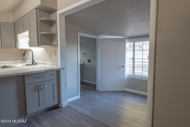 kitchen with gray cabinets, light hardwood / wood-style floors, and sink