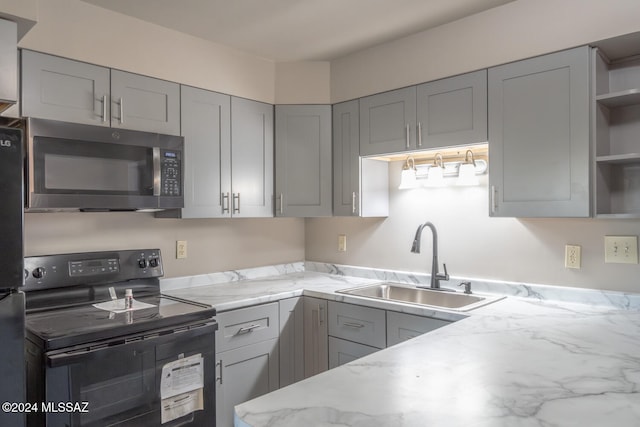 kitchen with black range with electric stovetop, gray cabinetry, and sink