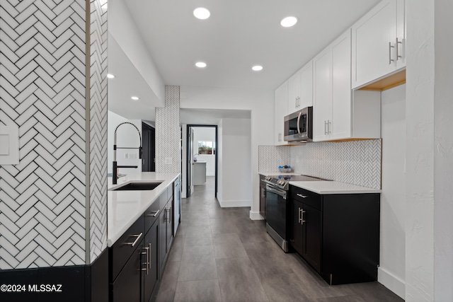 kitchen with backsplash, white cabinets, sink, and stainless steel appliances