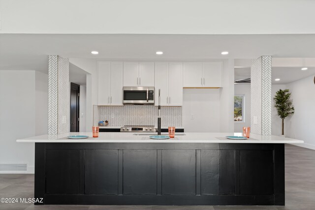 kitchen featuring white cabinetry, a large island with sink, and stainless steel appliances