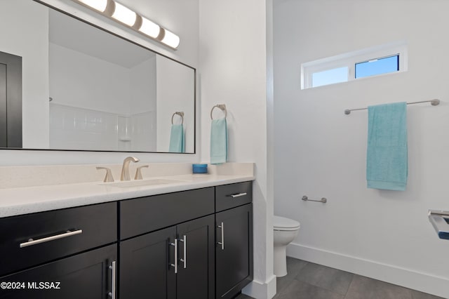 bathroom featuring tile patterned flooring, vanity, and toilet