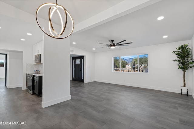 unfurnished living room with ceiling fan with notable chandelier