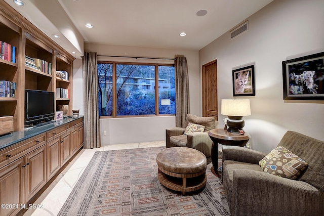 living area with light tile patterned floors and built in shelves