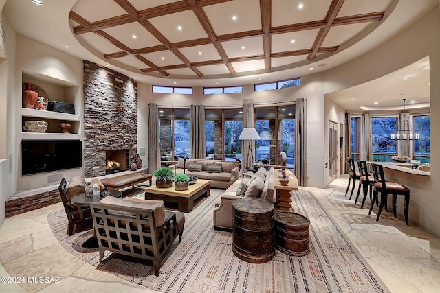 living room with beam ceiling, a high ceiling, coffered ceiling, built in features, and a fireplace