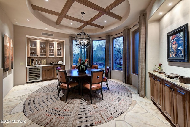 dining room featuring coffered ceiling, wine cooler, beamed ceiling, a chandelier, and indoor bar