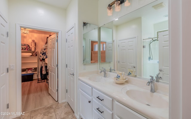 bathroom with vanity, tile patterned flooring, and a notable chandelier