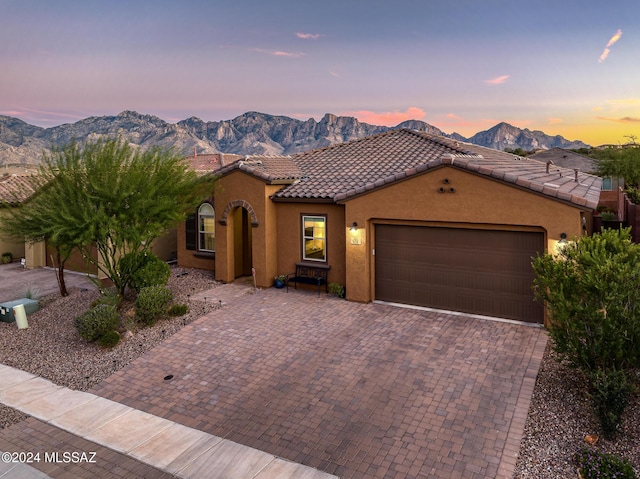 view of front facade featuring a tile roof, a mountain view, and stucco siding