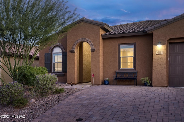 exterior entry at dusk with a garage