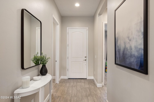 doorway to outside featuring baseboards and light wood-style floors