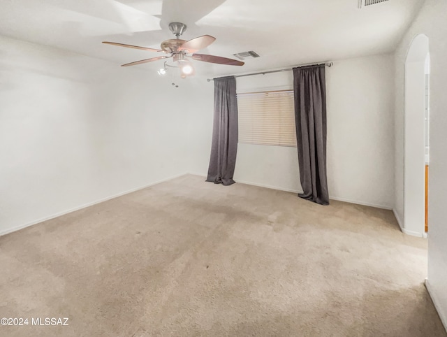 empty room featuring ceiling fan and light colored carpet