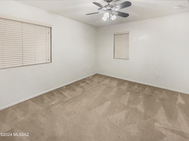 carpeted spare room with ceiling fan