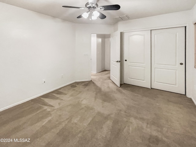 unfurnished bedroom featuring carpet, ceiling fan, and a closet