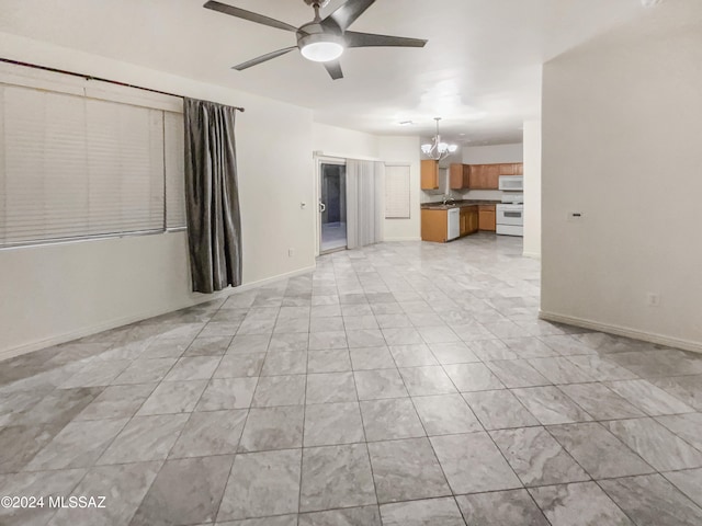 unfurnished living room with ceiling fan with notable chandelier and sink