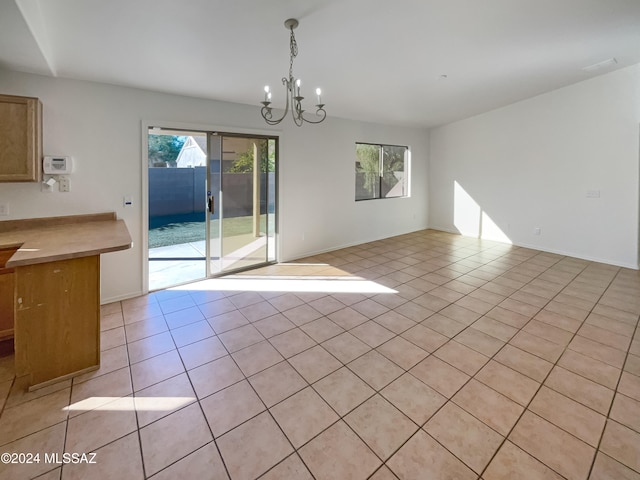 unfurnished dining area with light tile patterned flooring and a notable chandelier