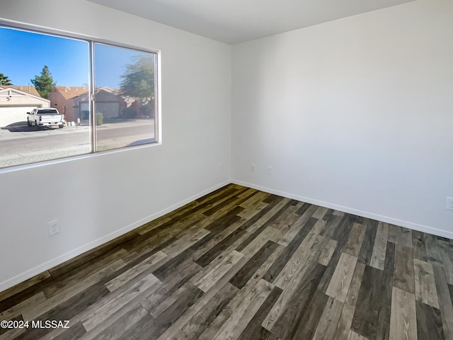 unfurnished room with dark wood-type flooring