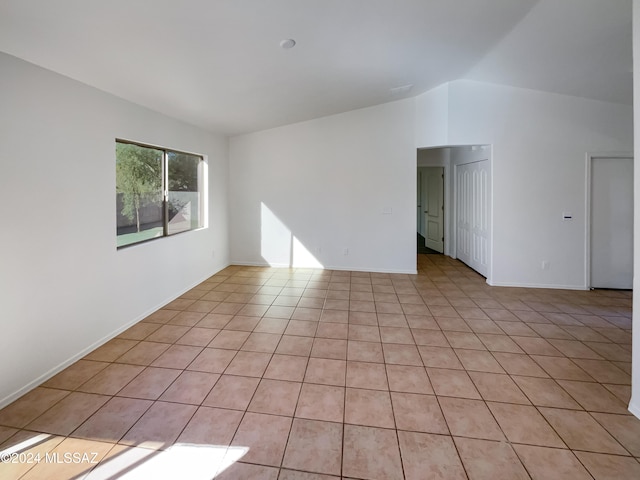 tiled empty room with vaulted ceiling